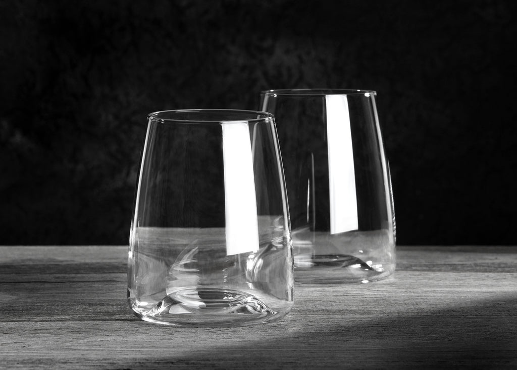 Zwei leere Wassergläser "Side" aus der VISION-Serie (2er-Set, 480 ml) stehen auf Holz vor dunklem Hintergrund. Lichtreflexe betonen das klare, moderne Design der Gläser.