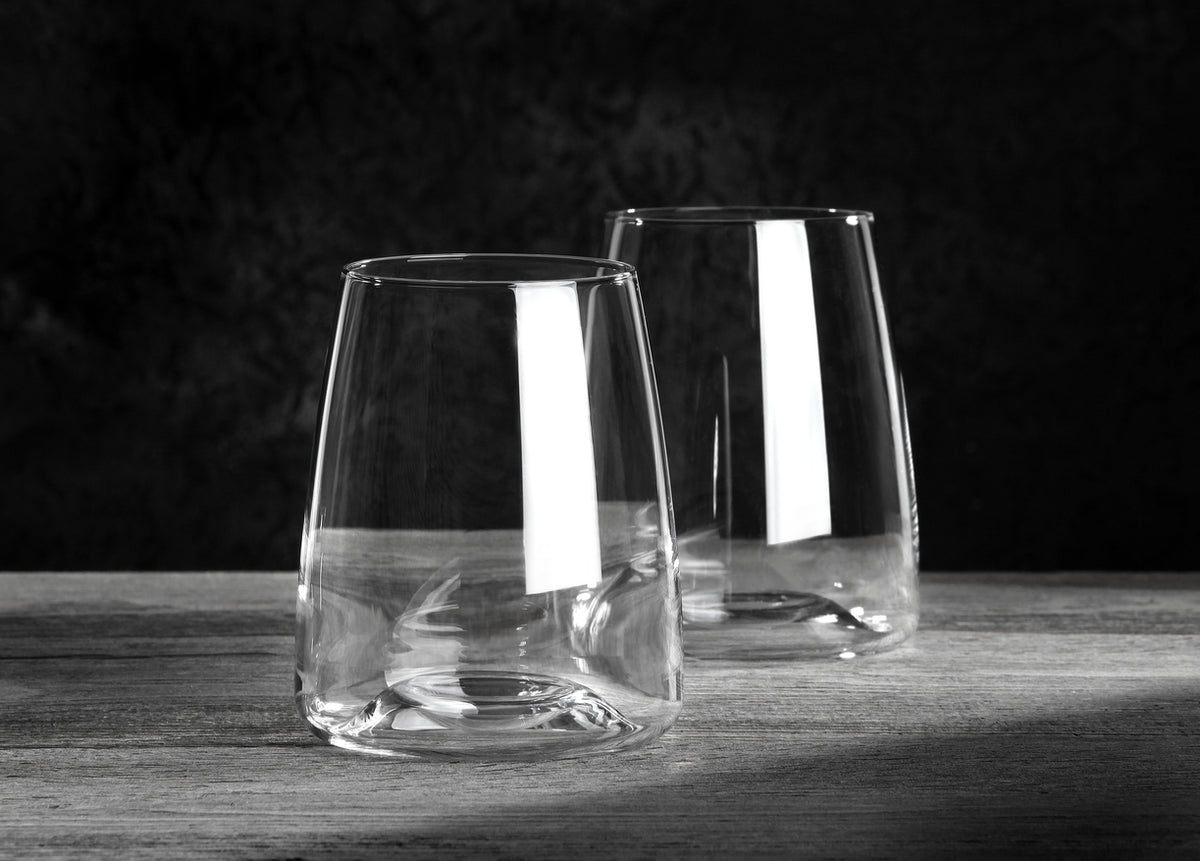 Zwei leere Wassergläser "Side" aus der VISION-Serie (2er-Set, 480 ml) stehen auf Holz vor dunklem Hintergrund. Lichtreflexe betonen das klare, moderne Design der Gläser.