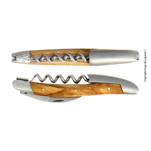 Das anspruchsvolle Design des Forge De Laguiole Kellnermesser Sommelier | Olive besteht aus einem klappbaren Korkenzieher mit elegantem Metallfinish und einem Griff aus Olivenholz. Es wird sowohl in geöffneter als auch geschlossener Position gezeigt und ist das ideale Werkzeug für jeden Sommelier, der Eindruck machen möchte.
