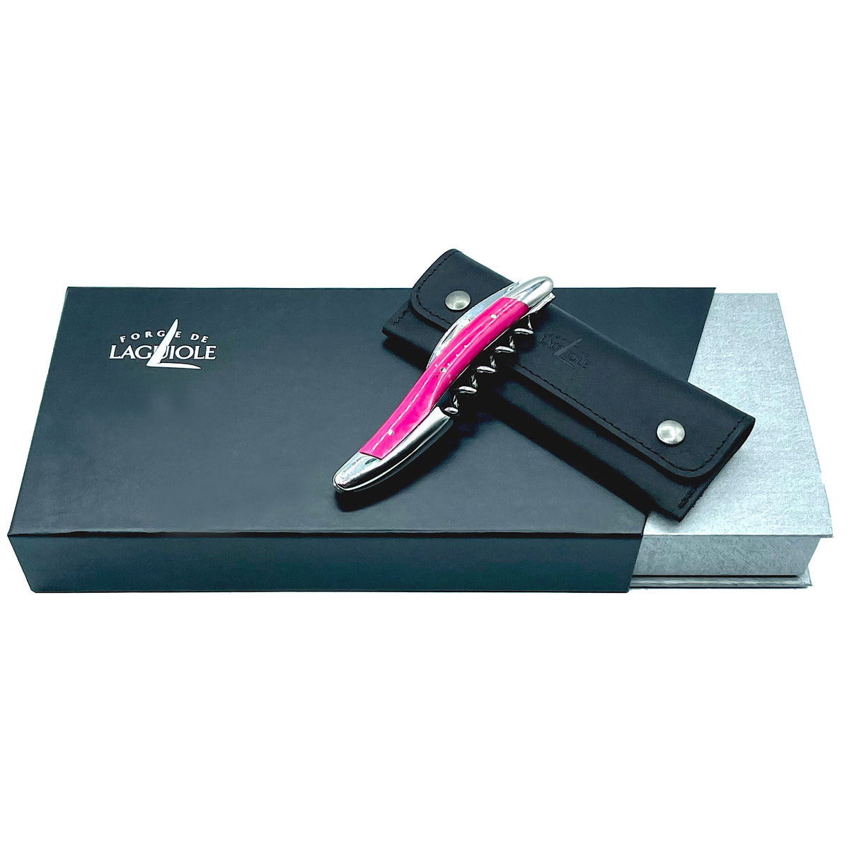 Ein Kellnermesser Sommelier von Forge De Laguiole in glänzendem Rosa liegt auf einem geschlossenen schwarzen Lederbeutel, der wiederum auf einer rechteckigen schwarz-grauen Geschenkbox ruht, die das Logo „Forge de Laguiole“ trägt, als Hinweis auf die Sommelier-Qualität.