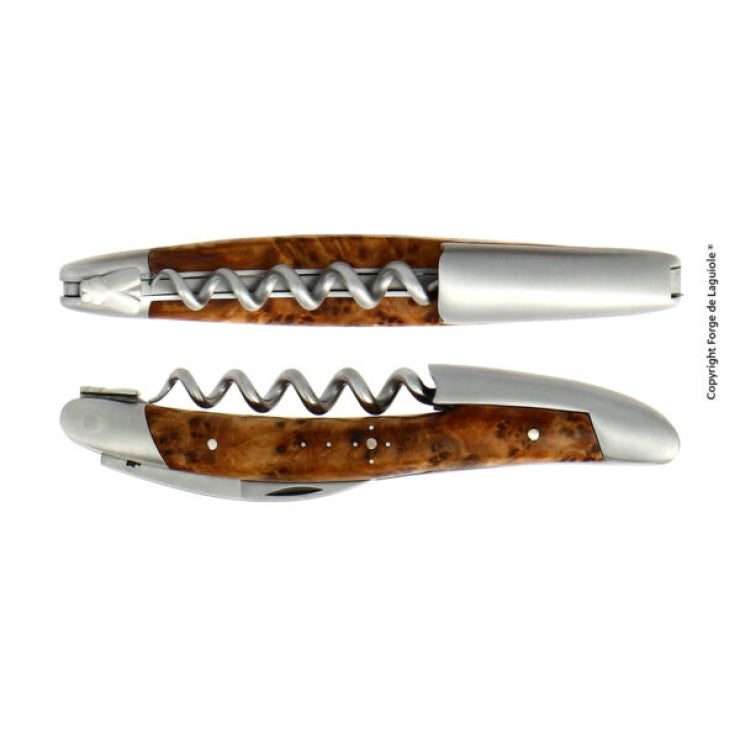 Zwei Ansichten des Kellnermessers Sommelier | Thuja von Forge De Laguiole, das einen faltbaren Korkenzieher mit einem wunderschön strukturierten Holzgriff und Metallakzenten aufweist. Die obere Ansicht zeigt ihn teilweise ausgefahren, während die untere Ansicht ihn vollständig gefaltet zeigt und seine elegante Handwerkskunst zur Schau stellt.