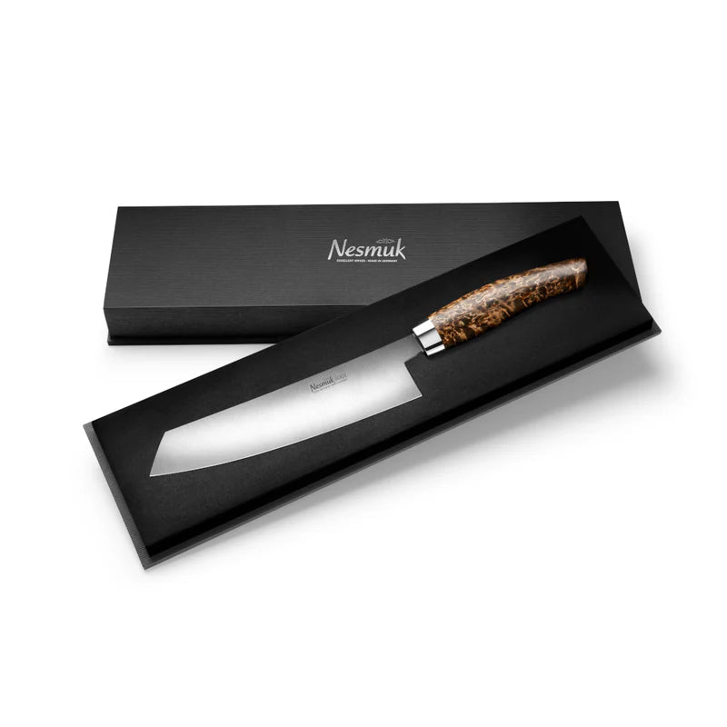 Ein elegantes Nesmuk Soul Kochmesser 180 mm mit scharfer, polierter Klinge und aufwendigem Holzgriff wird in einer schwarzen Geschenkbox präsentiert. Der Markenname „Nesmuk“ ist sowohl auf der Klinge als auch auf dem Deckel der Box deutlich zu sehen und unterstreicht die hochwertige Auswahl an Griffmaterialien.
