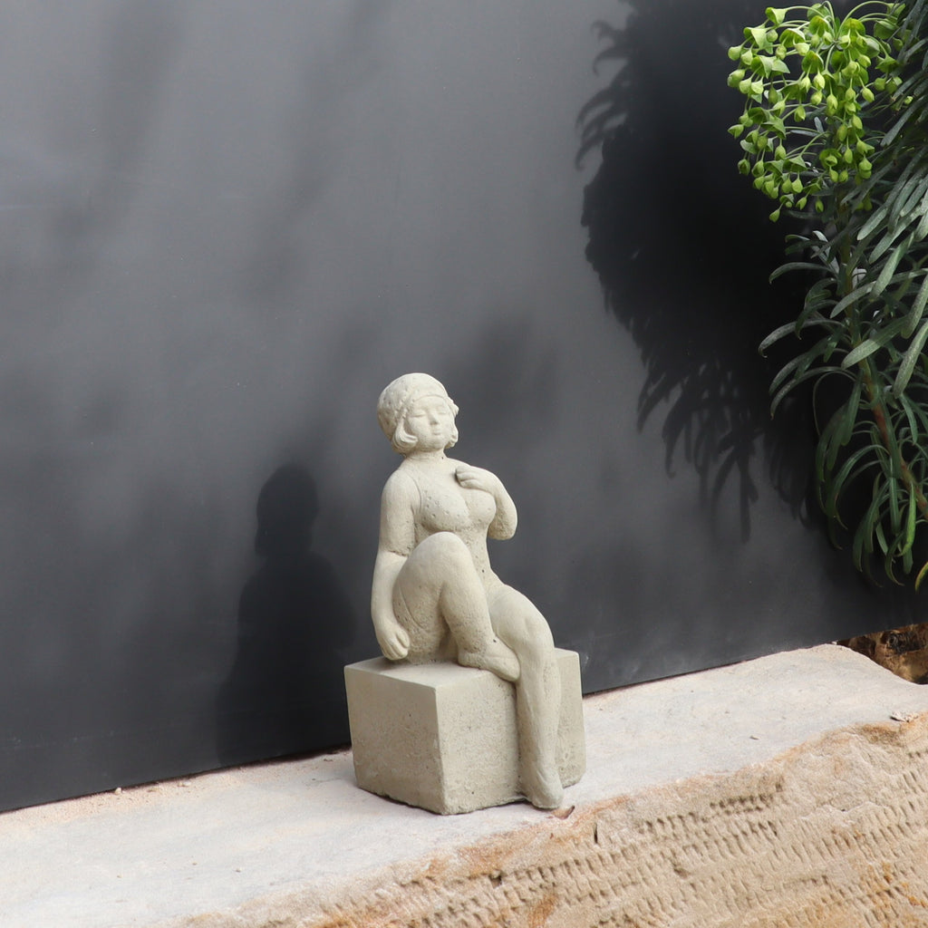 Die UV-beständige Gartenfigur "Badenixe" zeigt eine sitzende Frau und verleiht jedem Außenbereich zeitlose Eleganz.