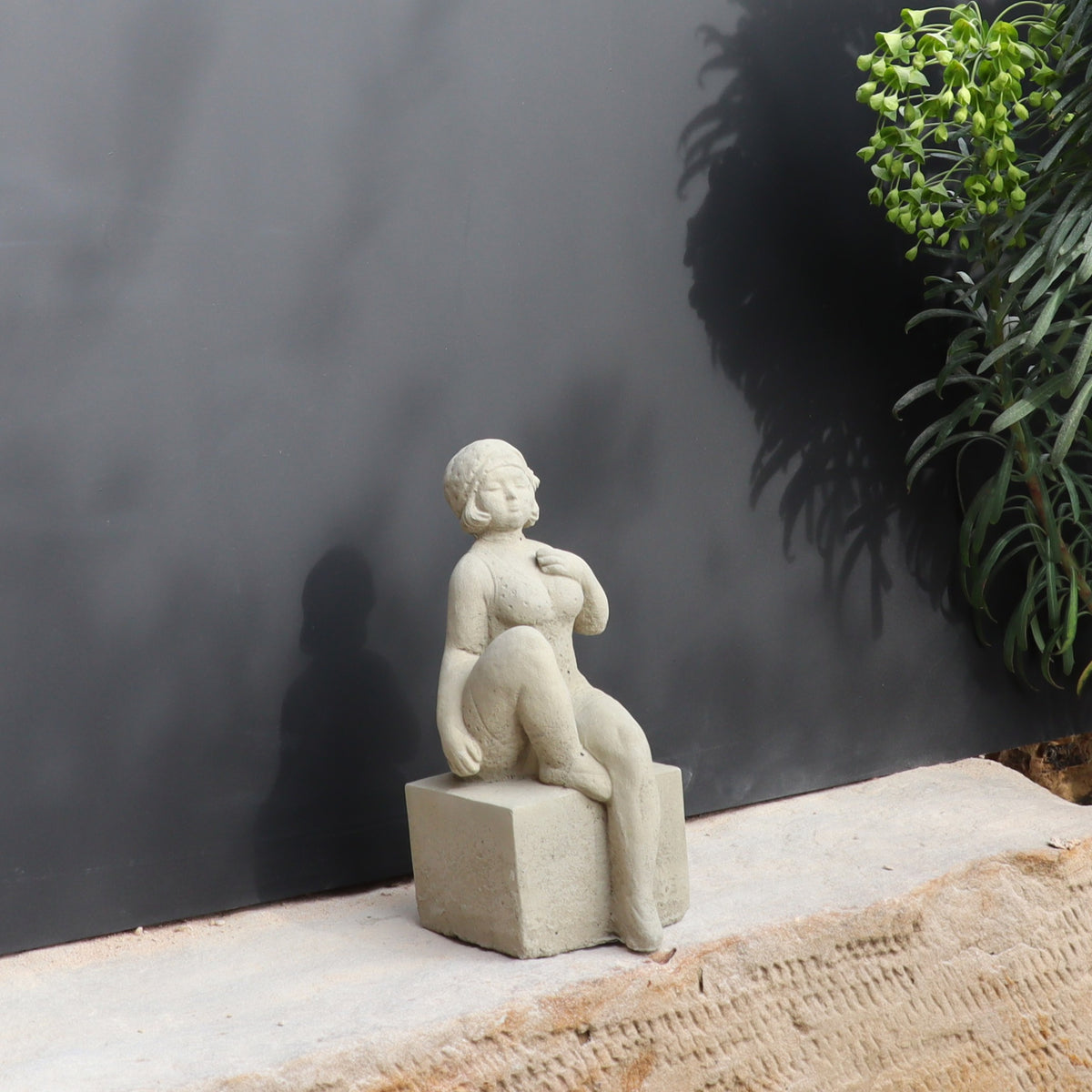 Die UV-beständige Gartenfigur "Badenixe" zeigt eine sitzende Frau und verleiht jedem Außenbereich zeitlose Eleganz.