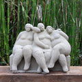 Die charmante Steinfigur "Freundschaft" zeigt drei vereint sitzende Frauen und bringt Gartenliebe in Ihr Zuhause - handgefertigt in Deutschland, mit grünen Bambusakzenten im Hintergrund.