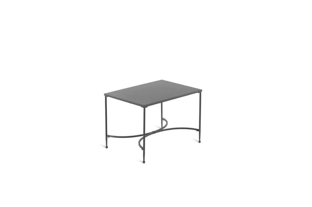 Der rechteckige Couchtisch Toscana 52 x 38 ist ein kleiner, rechteckiger Couchtisch mit Glasplatte, dünnen Metallbeinen und einer gewölbten Metallstütze darunter. Das von Toscana inspirierte Design ist minimalistisch, mit einer klaren Struktur und einem dunklen Metallrahmen, wodurch es sich vom schlichten weißen Hintergrund abhebt.