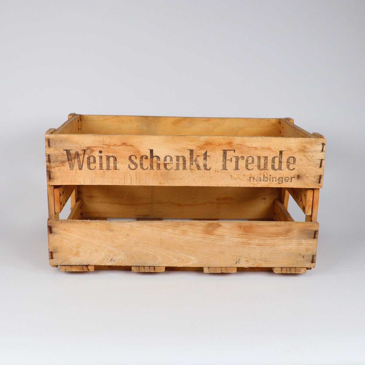Die Alte Weinkiste Holz Vintage aus der Pfalz mit dem deutschen Text „Wein schenkt Freude, Rabinger“ ist eine rustikale, charmante Holzkiste, die leer vor einem schlichten weißen Hintergrund präsentiert wird.