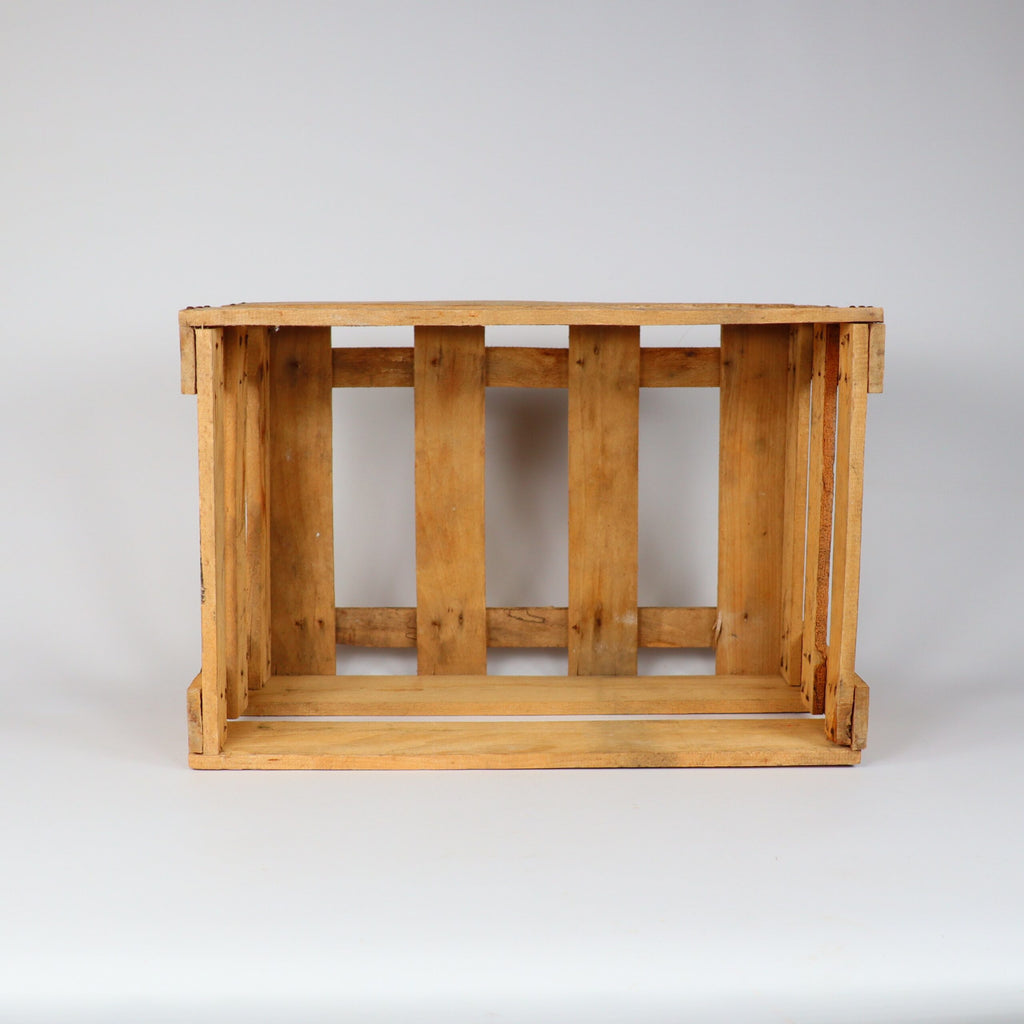 Eine Alte Weinkiste Holz Vintage aus der Pfalz mit Aufschrift, gekennzeichnet durch Lattenseiten und eine offene Oberseite, steht vor einem schlichten weißen Hintergrund. Die Kiste weist Gebrauchsspuren auf, mit sichtbarer Holzmaserung und kleinen Unvollkommenheiten, die ihren rustikalen Charme unterstreichen.