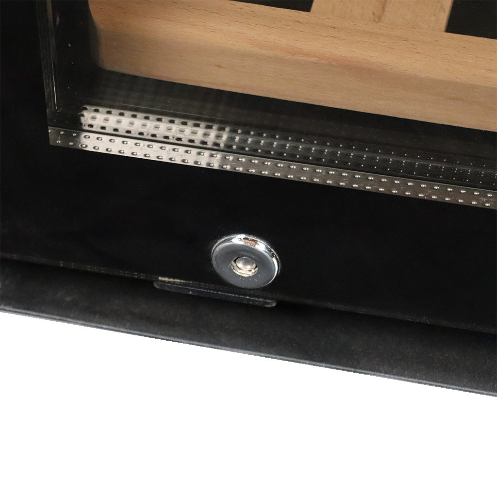 Nahaufnahme eines rechteckigen Holzobjekts mit einer Glasabdeckung, möglicherweise eine Vitrine oder ein Rahmen, mit einer metallischen Schraube oder einem Knopf in der Mitte des schwarzen Rahmens, der das Glas umgibt. Der dunkle Hintergrund erinnert an das schlanke Design, das für High-End-Geräte wie den CASO WineComfort 66 Weinkühlschrank 2 Zonen in Silber mit Fassholzgehäuse charakteristisch ist.