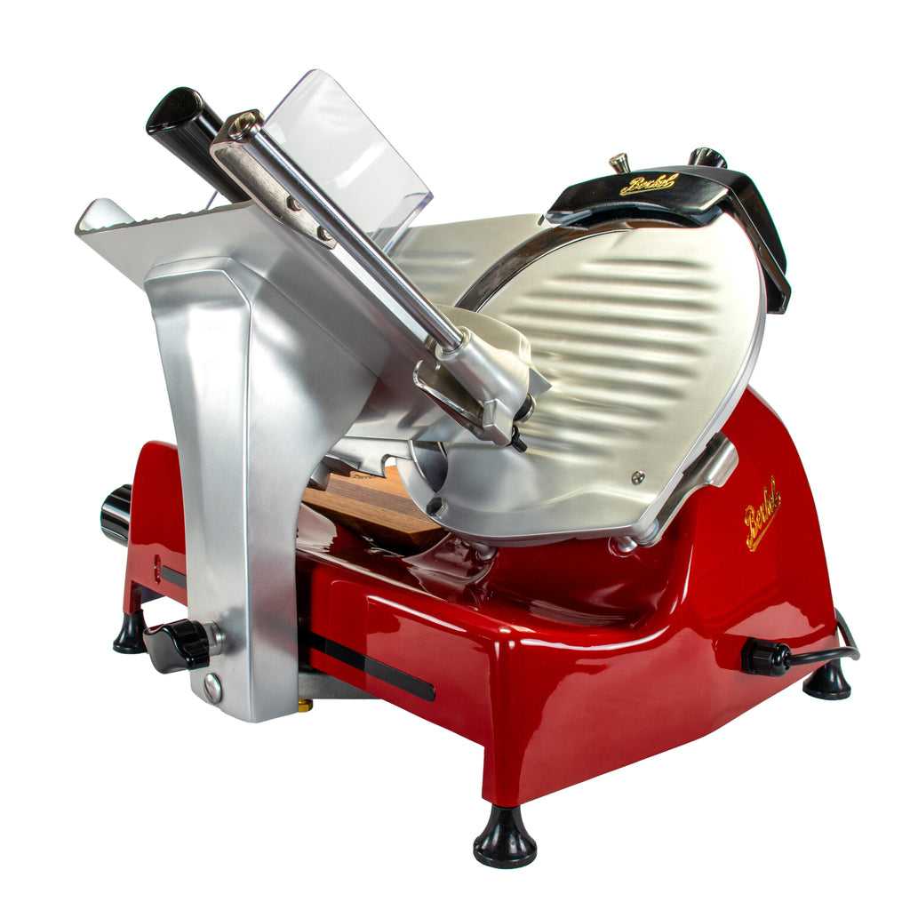Die Berkel Aufschnittmaschine Pro Line XS 25 Rot, Der Profi Allesschneider für Ihre Küche + 100% handgefertigtes Fassholzbrett Unikat ist in einem auffälligen rot-silbernen Farbschema mit einem großen Rundmesser dargestellt. Das Gerät verfügt über ein schlankes, metallisches Design, das mit Einstellknöpfen und einem Bediengriff ausgestattet ist. Es steht sicher auf vier gummierten Füßen für zusätzliche Stabilität. Der Name „Berkel“ ist prominent auf dem Gehäuse angebracht.