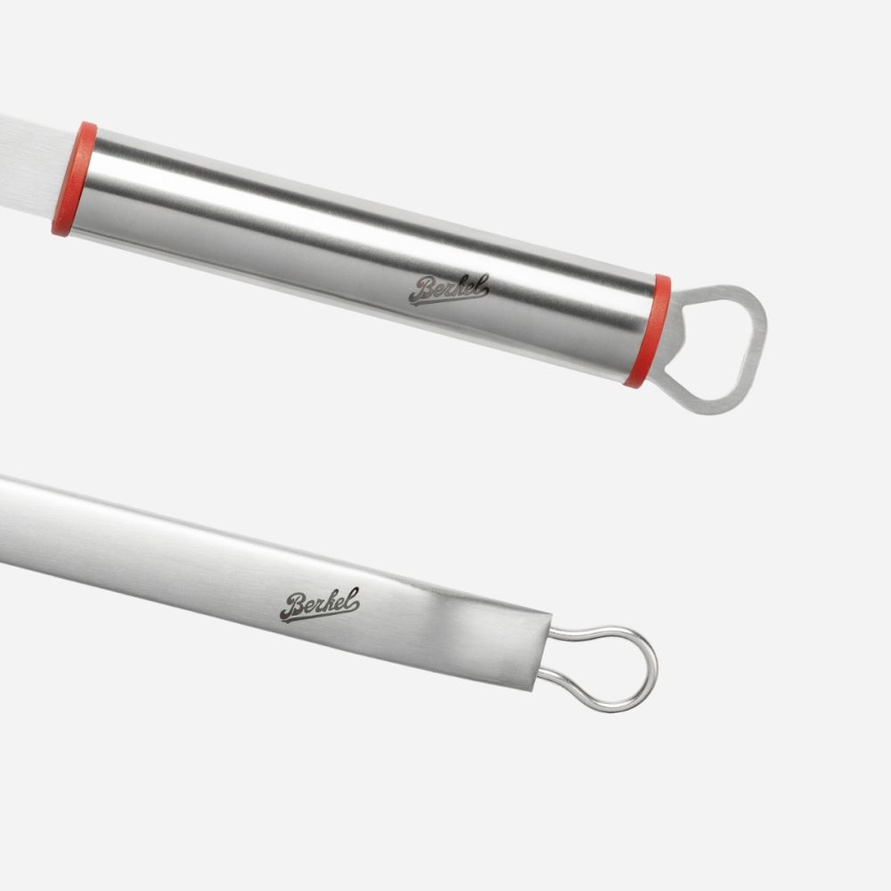 Nahaufnahme von zwei Berkel BBQ-Set-Edelstahlutensilien auf weißem Hintergrund. Ein Griff ist mit einem Flaschenöffner versehen, der andere mit einer Aufhängeschlaufe; beide haben rote Akzente und die Gravur "Berkel".