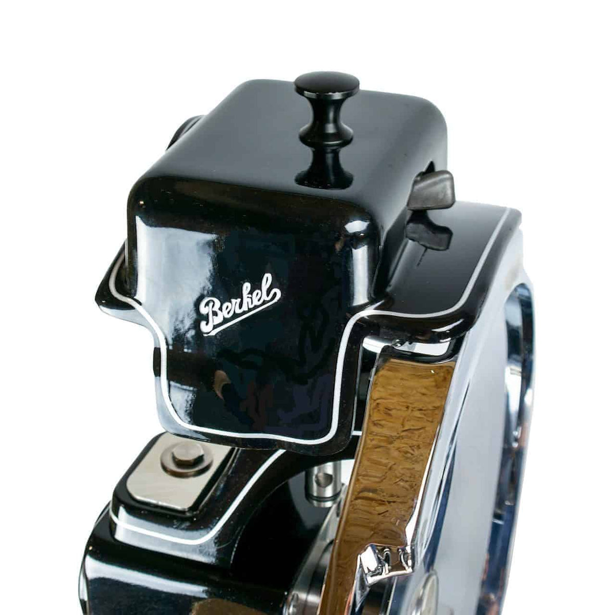 Nahaufnahme einer schwarz-chromierten Vintage-Fleischschneidemaschine von Berkel, wobei der obere Teil mit dem deutlich sichtbaren Markennamen im Mittelpunkt steht. Die Maschine hat eine glänzende Oberfläche und reflektiert das Umgebungslicht.