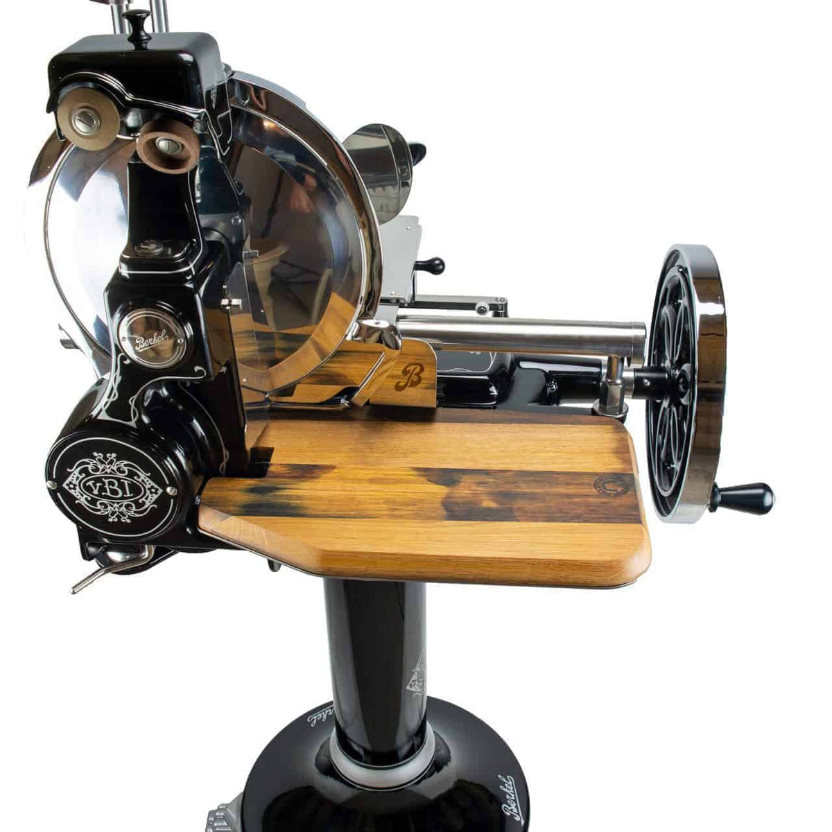Der Berkel Volano B114 ist ein traditioneller Fleischschneider im Vintage-Stil mit schwarzem Metallgehäuse und einer Fassholzbrett-Schneidefläche. Diese „manuelle Aufschnittmaschine“ verfügt über ein rundes Messer mit einer durchsichtigen Schutzhülle und einem kunstvollen Design auf der Hauptstruktur und steht stolz auf ihrem stabilen schwarzen Sockel.