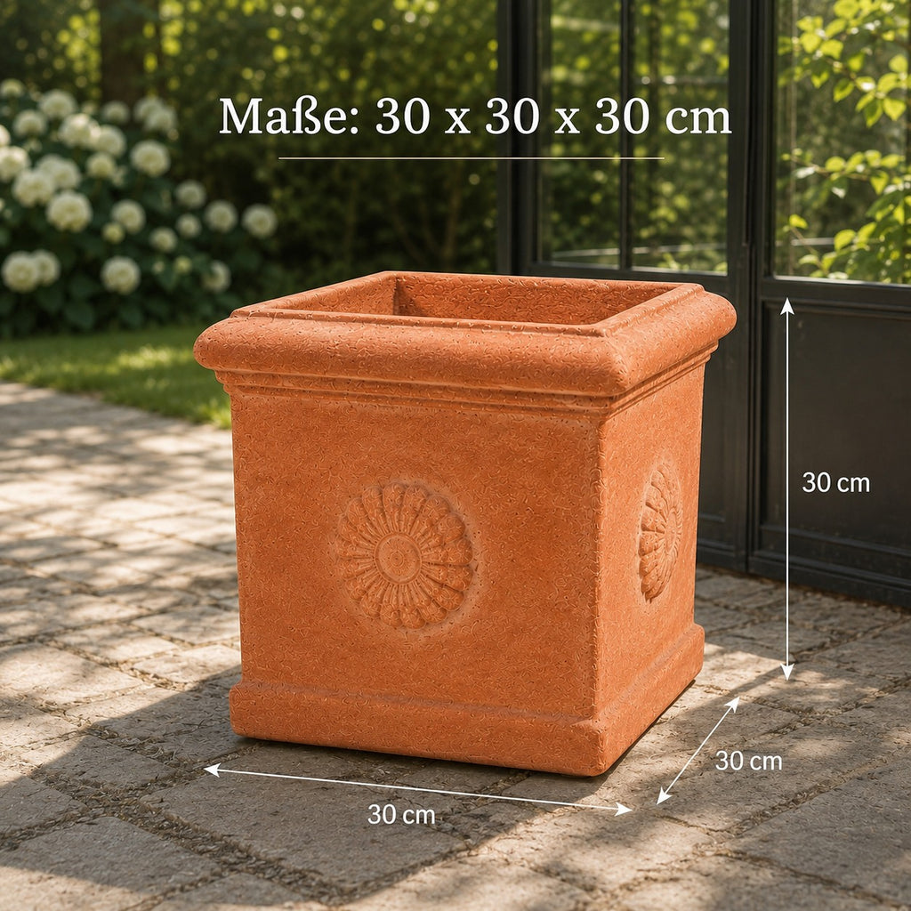 Quadratischer Terrakotta-Kübel „Rosone“ mit Sonnenornament auf jeder Seite, 30 × 30 × 30 cm groß, steht auf einer Steinterrasse neben einer Glastür; im Hintergrund blühende Sträucher. Die Maße sind im Bild eingezeichnet.