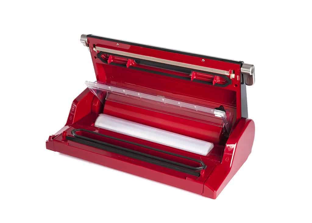 Eine rote Berkel Vacuum-Vakuummaschine mit geöffnetem Deckel gibt den Blick auf den Versiegelungsbereich und die Beutelrolle im Inneren frei. Diese Vakuumiermaschine zeichnet sich durch ein schlankes, modernes Design mit schwarzen Akzenten und einer transparenten Abdeckung für den Beutelrollenbereich aus.