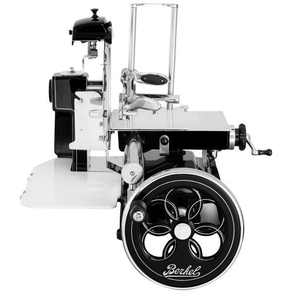 Der Berkel Volano B3 Schwarz, ein Fleischschneider im Vintage-Stil, verfügt über ein großes dekoratives Schwungrad. Die Aufschnittmaschine hat einen Griff für die manuelle Bedienung und eine glänzende Metalloberfläche mit schwarzen Akzenten, auf denen der Markenname „Berkel“ steht, was alles auf eine altmodische Ästhetik hindeutet. Außerdem wird sie mit einem Aufschnittbrett aus Fassholz geliefert.