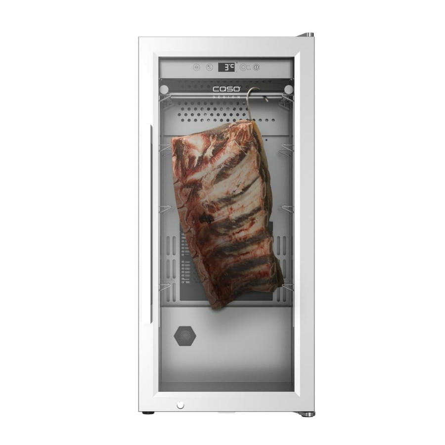 Eine Schrägansicht des Dry Ager CASO DryAged Master 63 Kühlschranks zeigt ein großes Stück Rippchen, das darin hängt. Der Kühlschrank verfügt über eine Temperaturanzeige mit 3°C, eine Glastür und einen Edelstahlrahmen. Der Markenname „CASO“ ist deutlich über der Tür zu sehen.