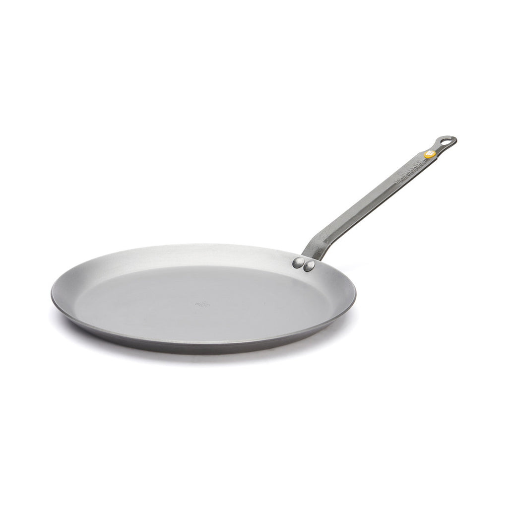 Die De Buyer Crêpe-Pfanne Mineral B, 26 cm Dm, ist eine flache, runde, silbergraue Pfanne mit langem Stiel auf weißem Grund - ideal für die Zubereitung zarter Crêpes oder Pfannkuchen.