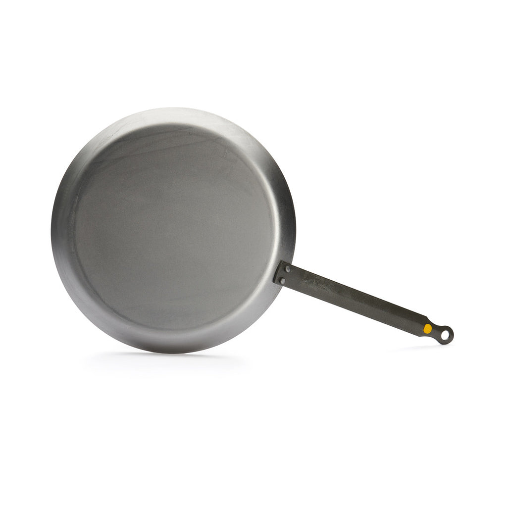 Die De Buyer Crêpe-Pfanne Mineral B, 26 cm Dm, mit langem schwarzem Stiel und flacher, glatter Oberfläche steht auf einem schlichten weißen Hintergrund.