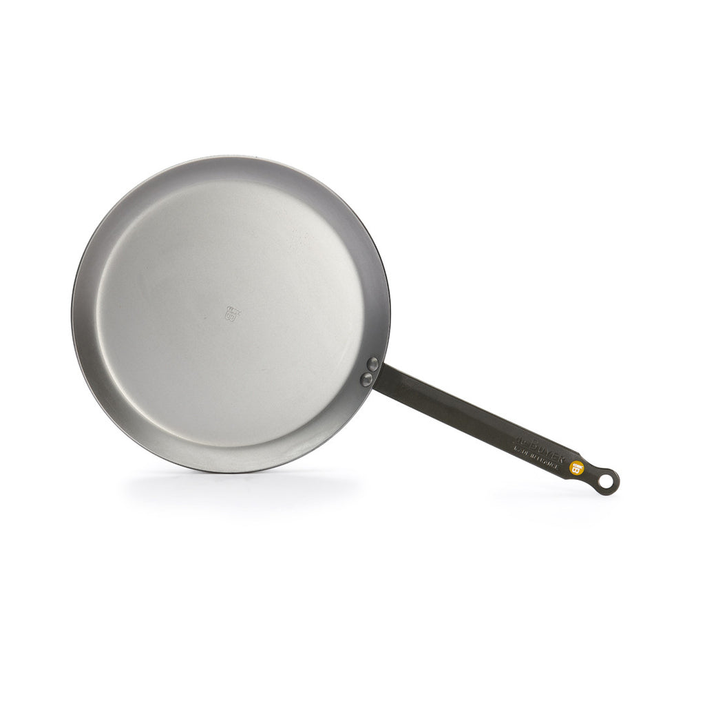 Die De Buyer Crêpe-Pfanne Mineral B (26 cm) ist eine runde, silberne Pfanne mit langem, geradem, schwarzem Stiel, abgebildet auf weißem Hintergrund.