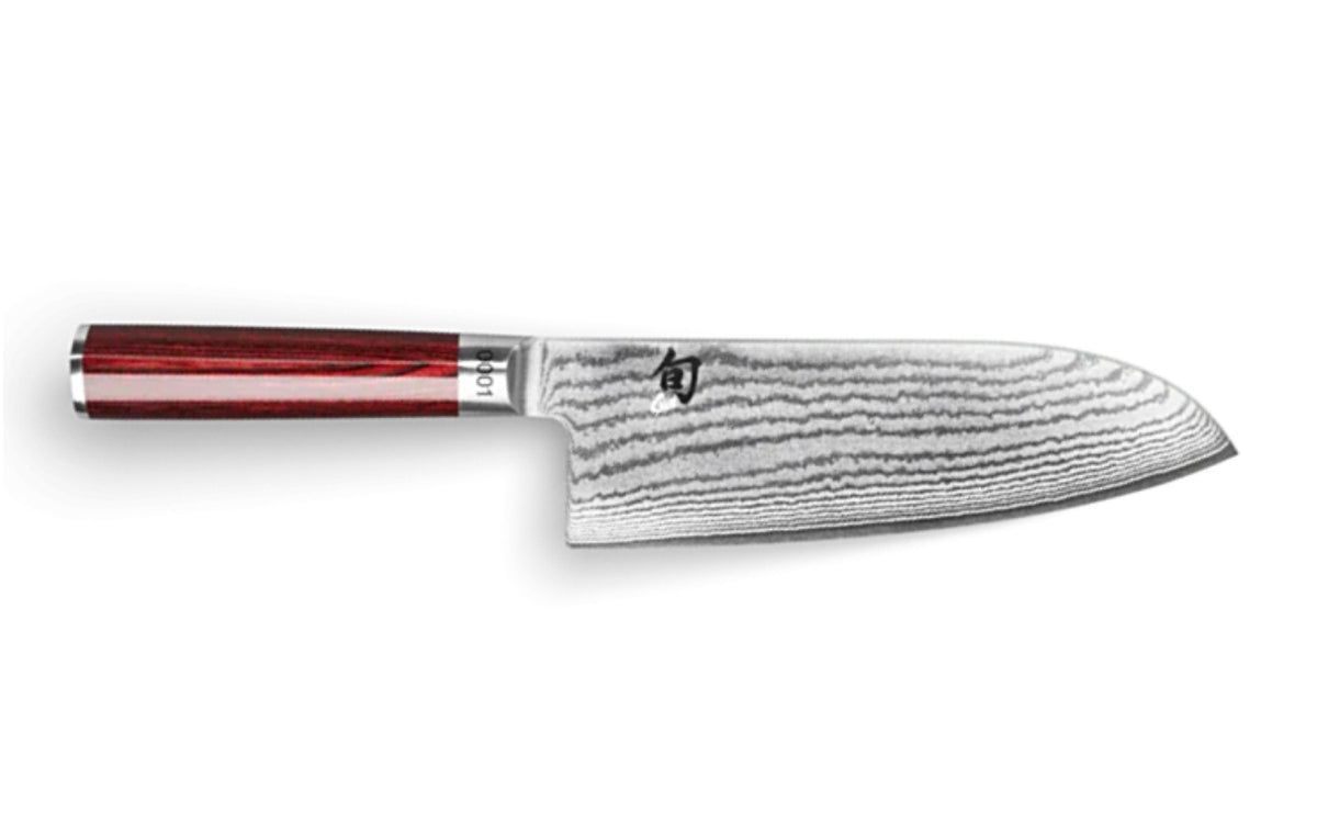 Das KAI X-MAS SELECTION DREAMBOX Shun Classic Red Santokumesser verfügt über eine Klinge aus Damaszenerstahl mit einem einzigartigen Wellenmuster und einem polierten Griff aus dunklem Holz. Horizontal auf einem schlichten weißen Hintergrund positioniert, repräsentiert dieses Stück die Eleganz der Shun Classic Red-Kollektion.