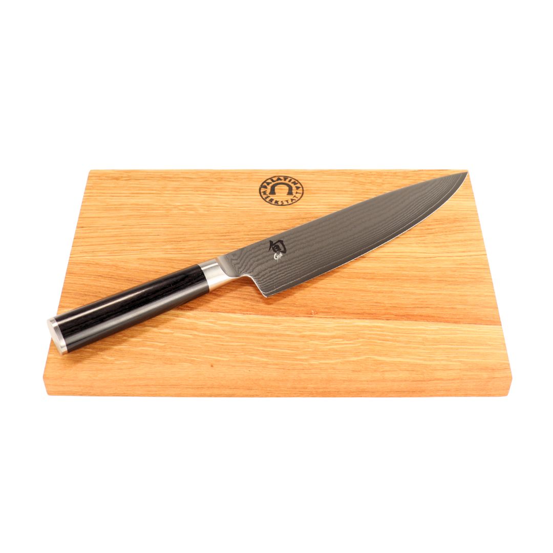 Das Kai Shun Classic DM-0706 Kochmesser mit 20 cm Klinge liegt auf dem 30x20 cm Schneidebrett aus Eichenholz - präzise, elegant und mit einem eingravierten Logo am oberen Rand des Brettes.