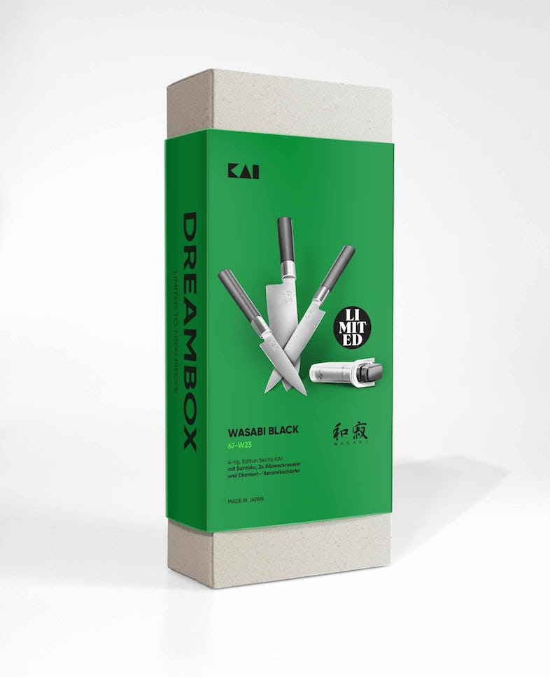 Eine grün-weiße Box mit der Aufschrift „DREAMBOX“ enthält das KAI Weihnachtsangebot 4-teiliges Geschenkset – Wasabi Black – limitiertes 1.000 Stk. Set japanischer Küchenmesser der Marke „KAI“. Die Box präsentiert vier verschiedene Messer mit schwarzen Griffen und silbernen Klingen und trägt die Worte „LIMITED“ und „MADE IN JAPAN“ auf der Verpackung, was sie zu einem perfekten KAI Weihnachtsangebot macht.