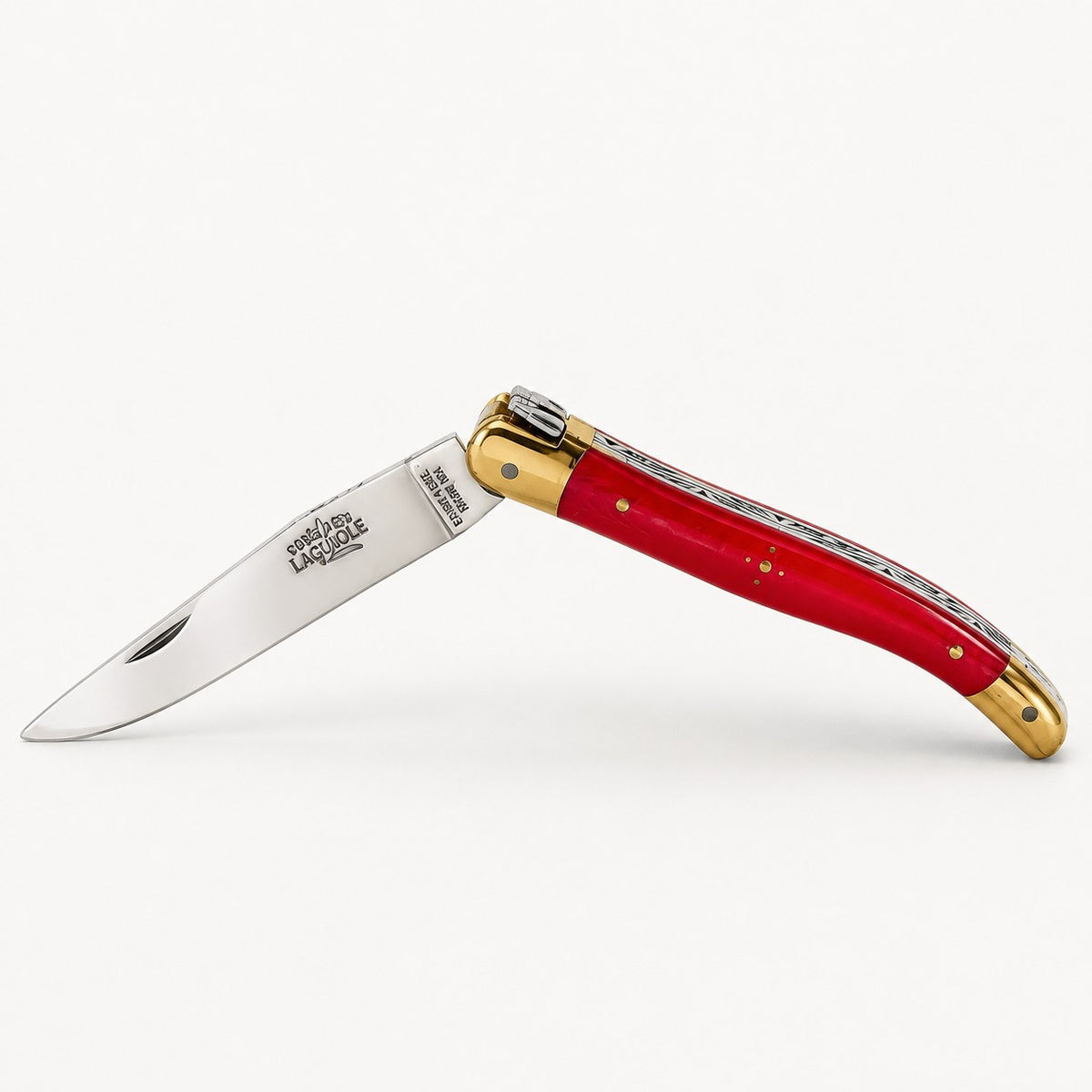 Ein Klappmesser mit einer glänzenden silbernen Klinge, einem roten Griff mit goldenen Akzenten und einem Ziermuster entlang des Rückens, das im geöffneten Zustand vor einem weißen Hintergrund abgebildet ist.