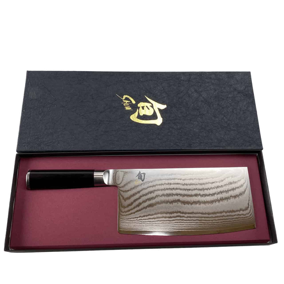 Abbildung eines hochwertigen Kai Shun Classic Chinakochmessers DM-0712 mit aufwendigen Mustern auf der Klinge, in einem eleganten schwarzen Etui mit roter Innenseite. Das Etui trägt goldene japanische Schriftzüge auf dem Deckel und das Messer hat einen schwarzen Griff. Ein passendes Schneidebrett aus Eiche, 30x22 cm, vervollständigt dieses elegante Set.