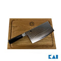 Ein hochwertiges Kai Shun Classic Chinakochmesser DM-0712 mit glänzender Stahlklinge und schwarzem Griff ruht auf einem 30x22 cm großen Schneidebrett aus Eiche. Das Schneidebrett hat eine Rille um die Kanten und ein kleines Logo in der oberen Mitte. Das KAI DM-0712-Logo erscheint in der unteren rechten Ecke.