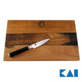 Auf einem 30x18 cm großen Holzschneidebrett aus Weinfassholz liegt schräg ein kleines Kai Shun Classic DM-0700 Officemesser (9 cm). Das Messer hat eine glänzende Klinge aus Damaszenerstahl und einen schwarzen Griff. In der Ecke ist ein Logo mit dem Text „KAI“ angebracht.