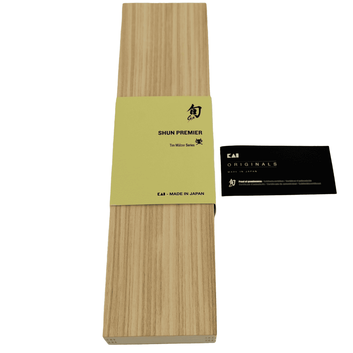 Eine rechteckige Holzbox mit einem hellgelben Band mit der Aufschrift „Shun Premier Tim Mälzer Series“ in schwarzer Schrift. Das Kai Shun Premier Geschenkset wird von einer schwarzen Karte mit weißer Schrift und einem Logo begleitet, das darauf hinweist, dass es von KAI und in Japan hergestellt wird. Es enthält exquisites Besteck wie das TDM-1715 Tourniermesser mit einer 5,5 cm langen Klinge und wird mit einem messerfreundlichen Schneidebrett aus Fassholz (Eiche) mit den Maßen 25 x 15 cm geliefert.