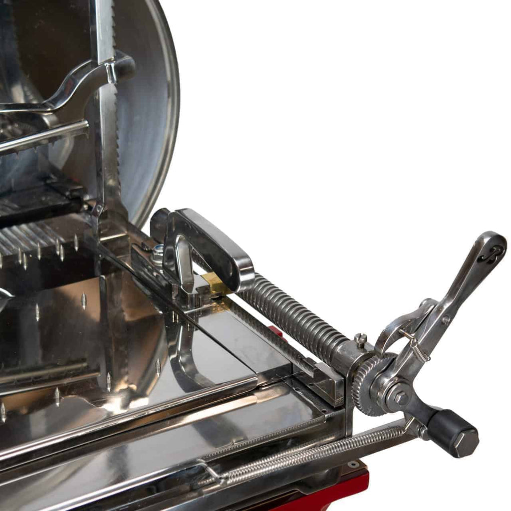 Nahaufnahme einer alten Berkel Volano L16 Schwungradmaschine in Rot, die ihre komplizierten Edelstahl- und Metallkomponenten einschließlich Griff, Schrauben und Gleitmechanismen zeigt. Das Bild fängt die polierten und reflektierenden Oberflächen dieser fein gearbeiteten Maschine ein, die einen Ständer und ein hölzernes Schneidebrett umfasst.