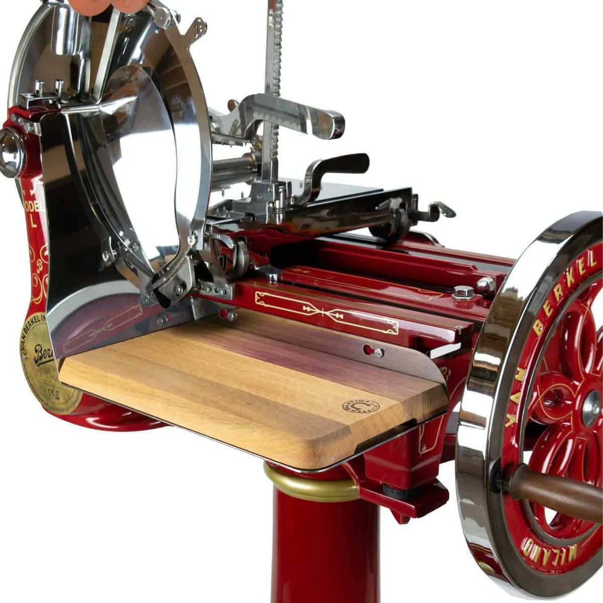 Eine Nahaufnahme einer Berkel Volano L16 nostalgischen Schwungrad-Aufschnittmaschine rot + handgefertigtem Einlegebrett hebt ihr Vintage-Design in Rot und Gold mit einer glänzenden Metallklinge hervor. Das handbetriebene Rad und die detaillierten Metallkomponenten sind deutlich sichtbar und zeigen das komplizierte Design und die Handwerkskunst dieses Fleischschneiders.