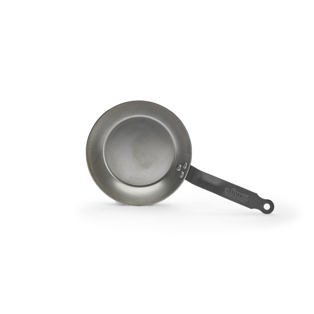 Eine De Buyer Lyonnaise Bratpfanne Carbone Plus mit schwarzem Griff ist von oben auf einem weißen Hintergrund abgebildet.