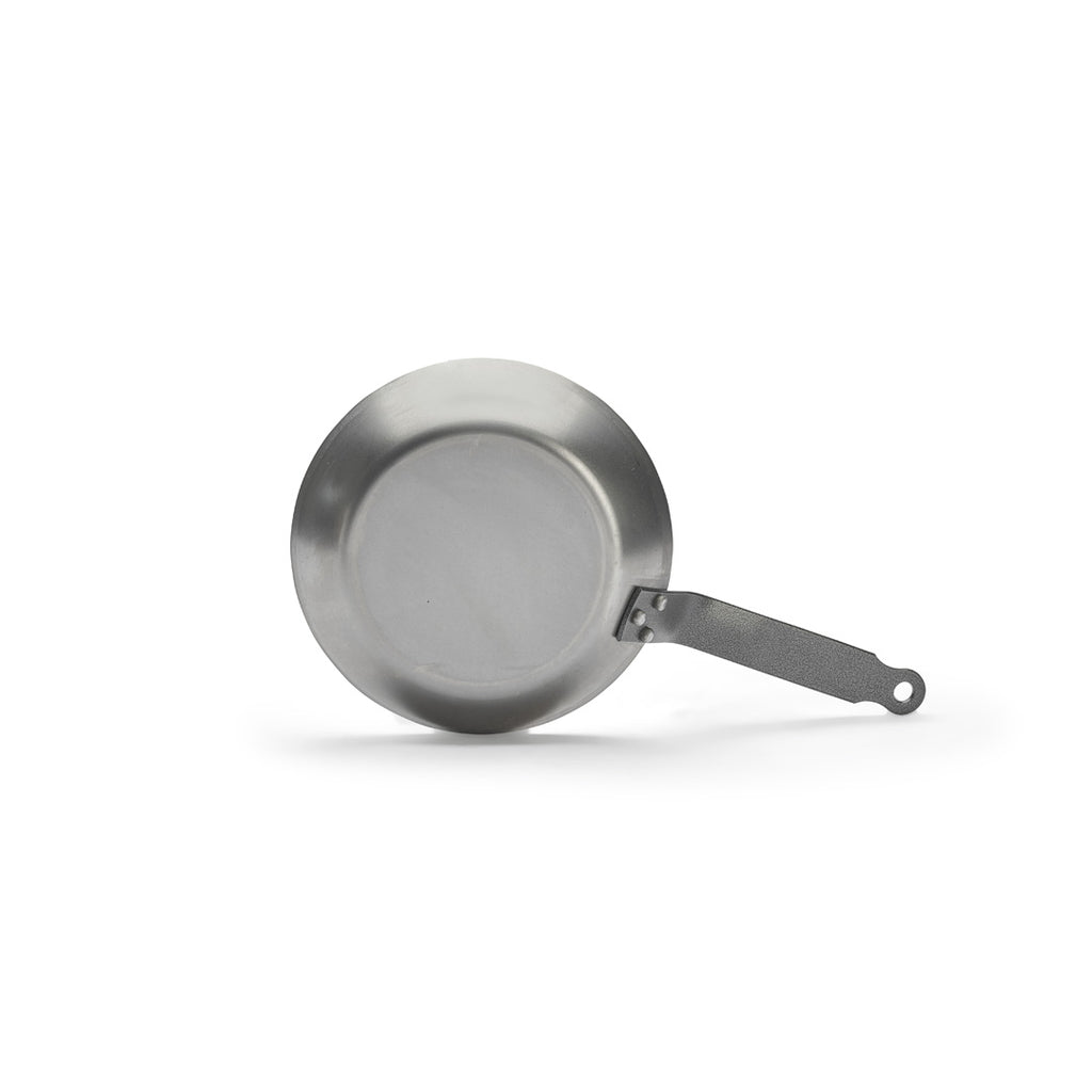 Die De Buyer Lyonnaise Bratpfanne Carbone Plus aus Carbonstahl mit flachem Boden und langem, strukturiertem Griff wurde vor weißem Hintergrund fotografiert.