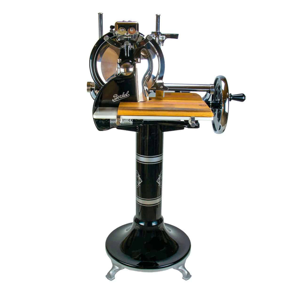 Der Berkel Volano P15 schwarz ist ein manueller Fleischschneider im Vintage-Stil mit Handkurbel, hölzernem Schneidebrett und aufwendigen Details. Diese manuelle Aufschnittmaschine ist auf einem Sockel montiert und verbindet auf schöne Weise Funktionalität mit klassischem Retro-Design.