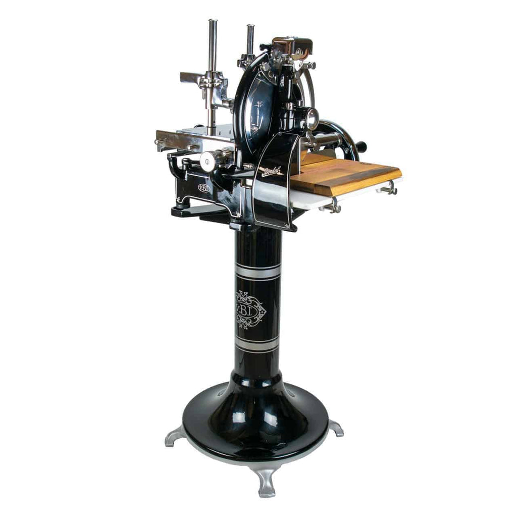 Der Berkel Volano P15 schwarz, ein klassischer manueller Fleischschneider mit Schwungrad und eingebautem Schneidebrett aus Holz, ist auf einem verzierten Sockel montiert. Diese elegante Maschine verfügt über ein rundes Messer und verschiedene Einstellhebel und vereint sowohl Funktionalität als auch Ästhetik.
