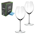 Das Rotweinglas Riedel Performance Syrah 2er Set mit Poliertuch besteht aus zwei eleganten klaren Weingläsern mit hohen Stielen, die neben einer eleganten schwarz-grünen Box präsentiert werden. Im Set enthalten ist ein hellblaues Poliertuch, ideal, um Ihre Syrah-Gläser glänzend zu halten.