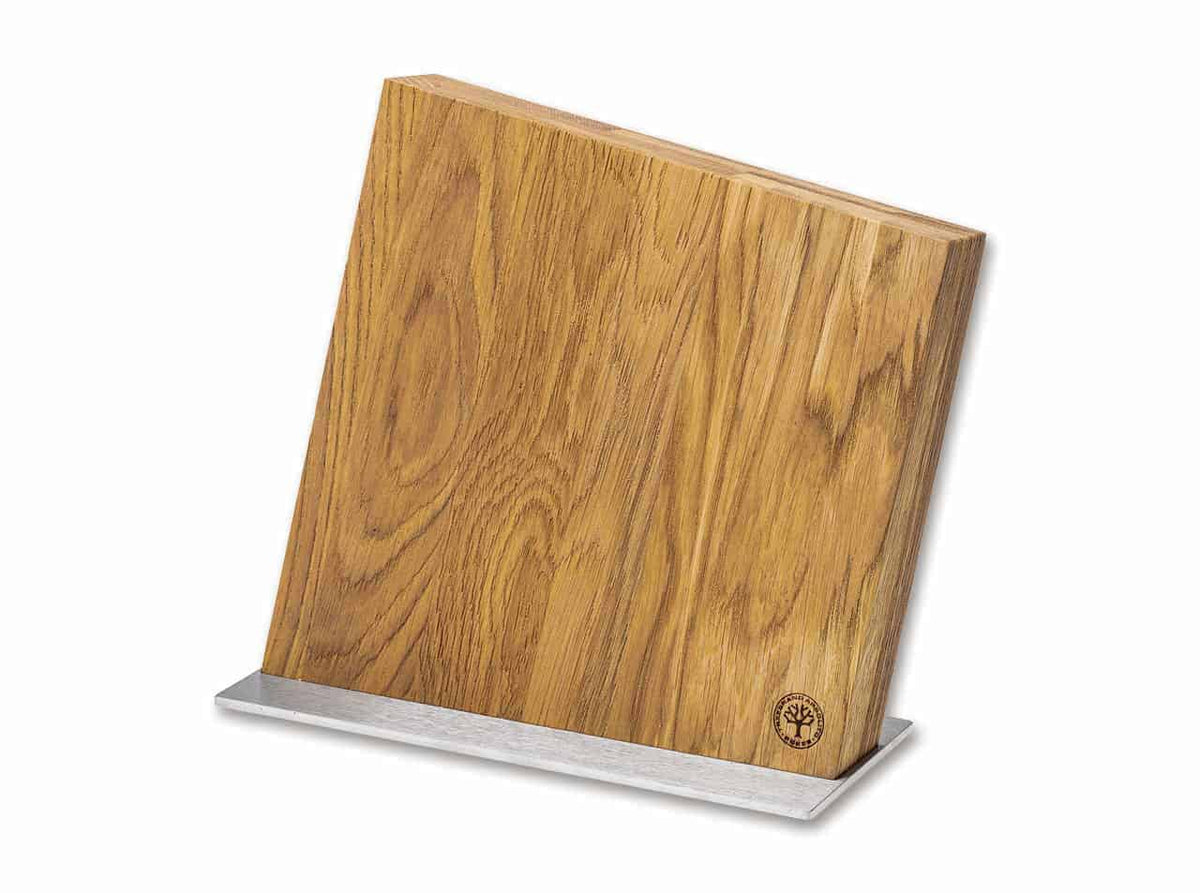 Der Böker Manufaktur Magnet-Messerblock Style, erhältlich in verschiedenen Farben, zeichnet sich durch ein schlichtes und minimalistisches Design mit natürlicher Holzmaserung aus. Der Block steht auf einem silberfarbenen Metallsockel, hat ein kleines, rundes Logo in der unteren rechten Ecke und ist leicht nach hinten geneigt.