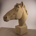 Die handgefertigte Steinfigur "Pferd groß" in Beige steht auf einem quadratischen Sockel. Die realistischen, detailreichen Gesichtszüge machen diese Skulptur vor schlichtem Hintergrund besonders eindrucksvoll.