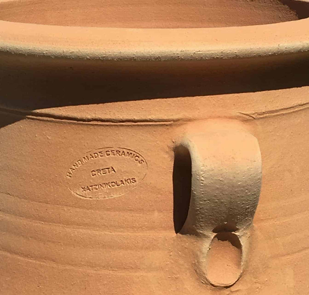 Nahaufnahme des frostfesten Amphore Garten „Thymus“, H=50cm, mit strukturiertem Griff und eingeprägter Aufschrift „HAND MADE CERAMICS CRETA KATRINAKOLAKIS“. Der rustikale Keramiktopf hat eine raue, erdige Oberfläche, die sich perfekt zur Präsentation von Pflanzen wie Thymus eignet.