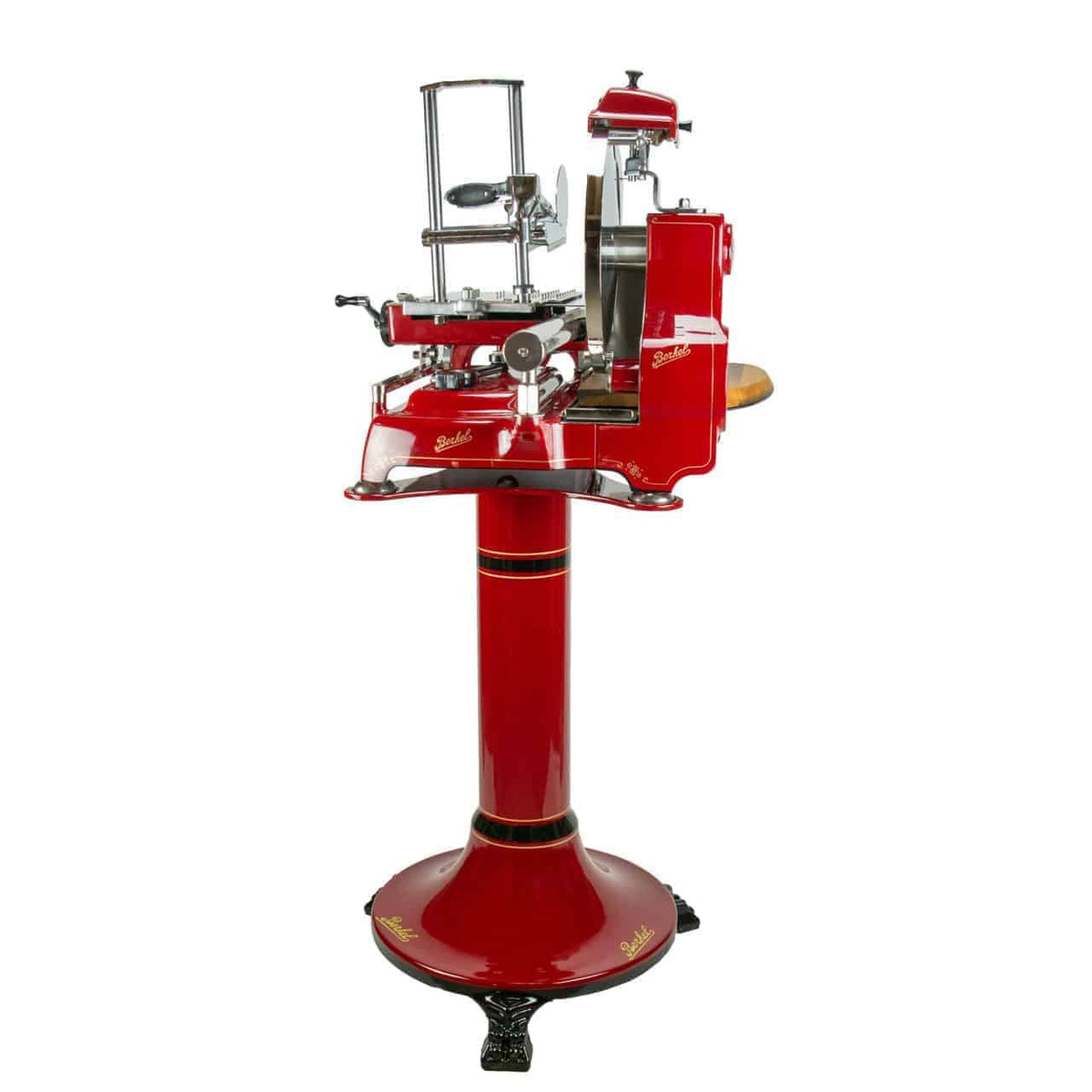 Ein Aufschnittgerät für rotes Fleisch im Vintage-Stil, ähnlich der Aufschnittmaschine Berkel Volano Tribute Rot, mit dekorativem Blumenrad und vertikalem Ständer. Diese Maschine verfügt über Chromakzente, ein rundes Messer zum Schneiden und ein mitgeliefertes Schneidebrett aus Fassholz. Ein Laib Brot wird zum Schneiden positioniert. Das Aufschnittgerät hat ein kunstvolles Design und ist auf einem stabilen Sockel montiert.