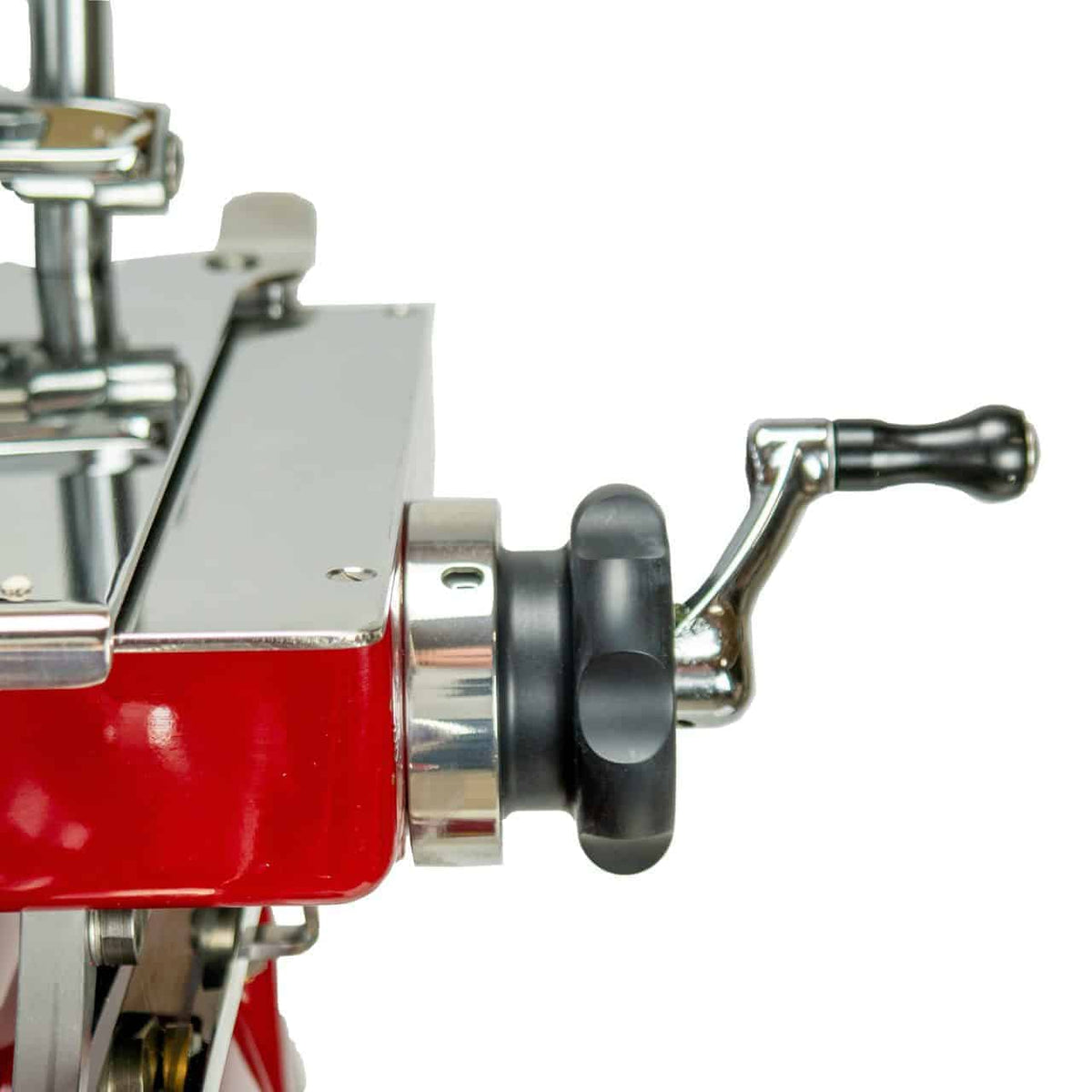 Nahaufnahme eines glänzenden, metallischen Handkurbelmechanismus an einer roten Berkel Volano Tribute Rot Aufschnittmaschine mit Blumenschwungrad. Der Kurbelgriff ist schwarz und durch einen polierten silbernen Arm mit dem Hauptkörper der Maschine verbunden. Die Oberfläche reflektiert Licht und weist auf ein sauberes und gepflegtes Erscheinungsbild hin.