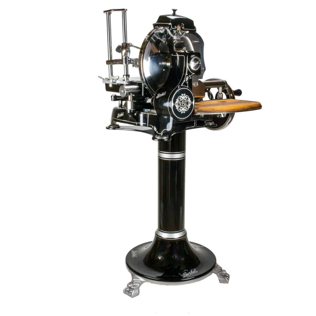 Wir präsentieren den Berkel Volano Tribute, einen schwarzen Handschneider im Vintage-Stil mit Blumenschwungrad-Design. Dieses Modell verfügt über kunstvolle Details, eine Handkurbel mit Holzgriff und wird komplett mit einem Ständer und einem Schneidebrett aus Fassholz geliefert. Der Schneider verfügt über Metallzahnräder, -komponenten und verschiedene Einstellhebel für präzises Schneiden.