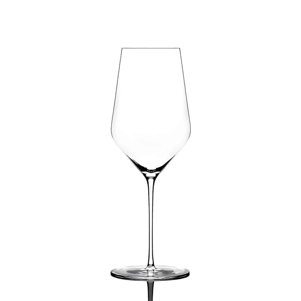 Ein klares, leeres, mundgeblasenes Weißweinglas von Zaltoglas Glasmanufaktur Denk'Art mit hohem Stiel und breiter, konischer Schale steht aufrecht auf einer reflektierenden Oberfläche vor einem weißen Hintergrund.