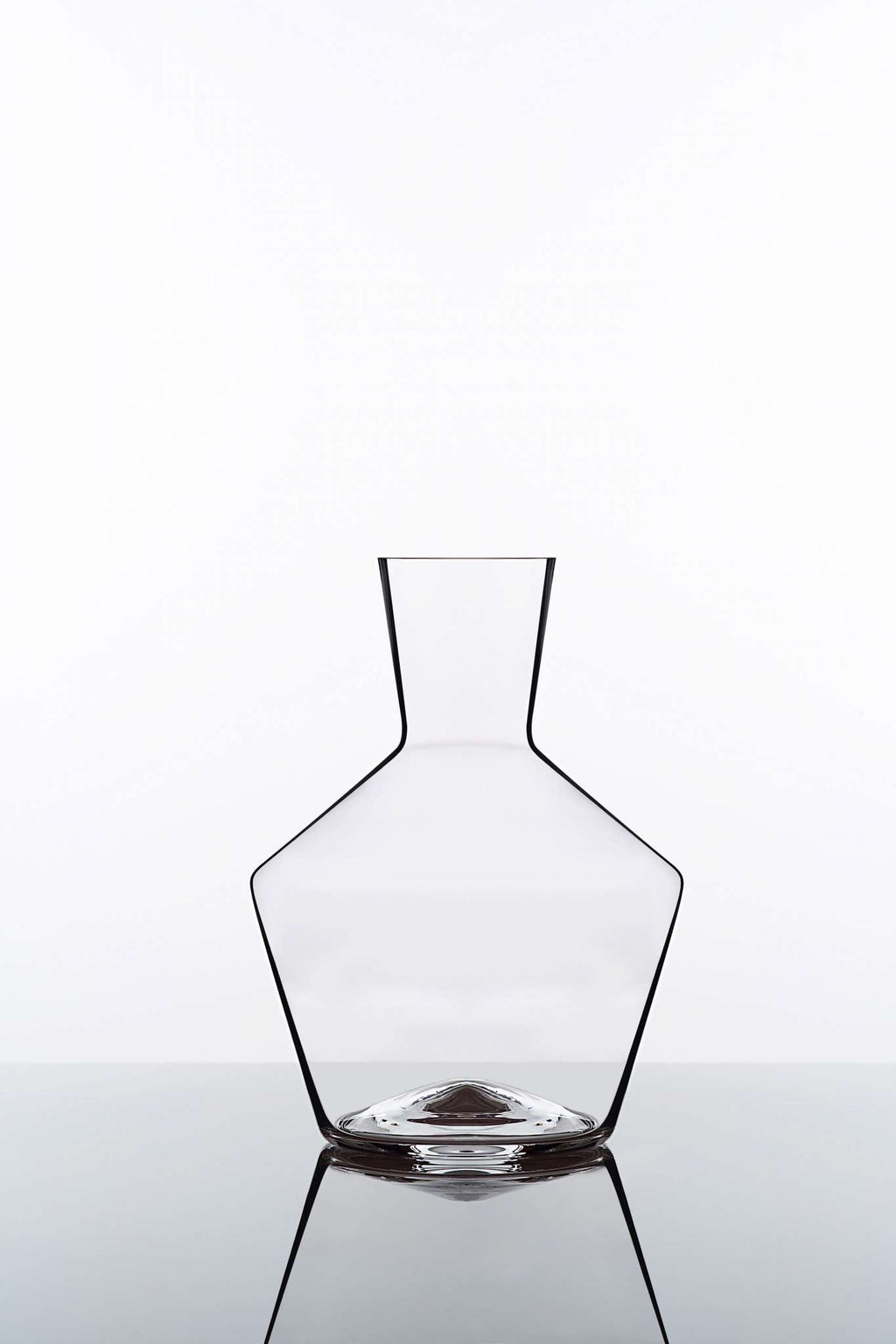 Eine elegante, moderne Glasvase mit eckigen Designelementen, die einen breiten Boden aufweist, der sich nach innen zu einem schmalen Hals verjüngt. Die Vase ist leer und steht vor einem schlichten weißen Hintergrund, wobei ihre Spiegelung auf einer glänzenden Oberfläche darunter sichtbar ist.