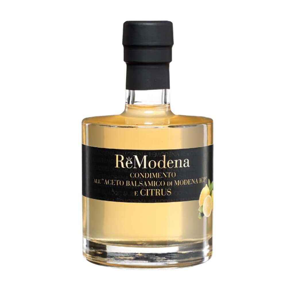 Eine 250 ml Flasche ReModena Balsamico Essig in einer seiner verschiedenen Sorten, beschriftet mit „Aceto Balsamico di Modena IGP e Citrus“. Die zylindrische Flasche trägt ein schwarzes Etikett mit einer Zitronenabbildung und ist mit einem schwarzen Stopfen verschlossen. Der Essig hat einen goldenen Farbton.